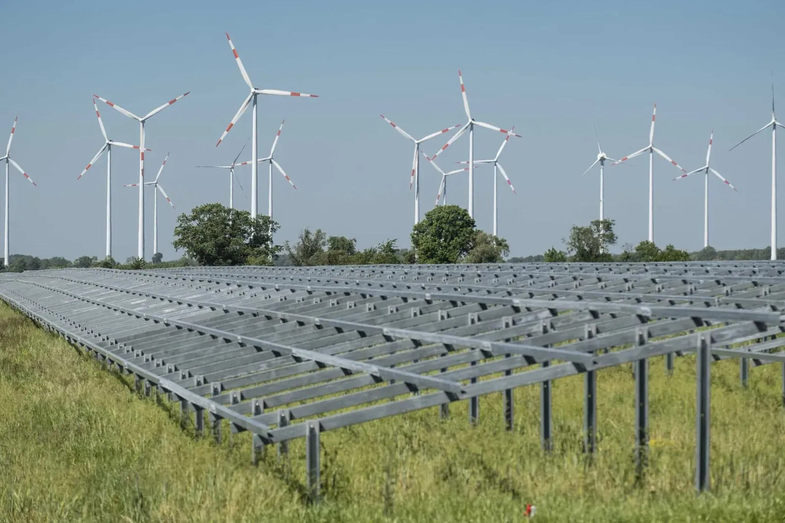 File di moduli a Schönermark con le turbine eoliche sullo sfondo